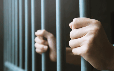 a man holding to a cell