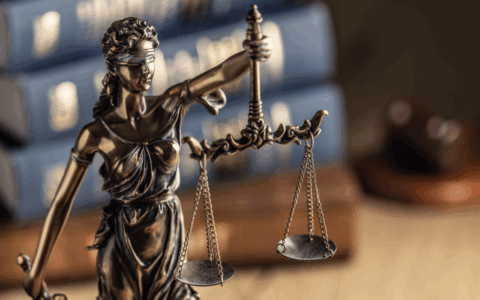 a blinfolded woman holding a scale