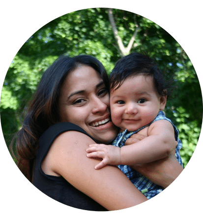 a mother smiling while holding her daughter